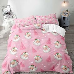 a pink bed with santa claus on it and snowflakes all over the comforter