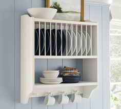 a white shelf with plates and cups on it