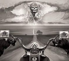 two hands holding up the handlebars of a motorcycle with a skull on it