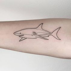 a black and white photo of a shark tattoo on the arm