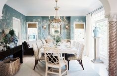 a dining room table with chairs and a chandelier hanging from it's ceiling