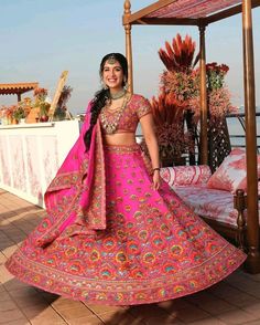 a woman in a pink lehenga posing for the camera