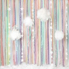 the wall is decorated with stars, clouds and streamers in pastel hues