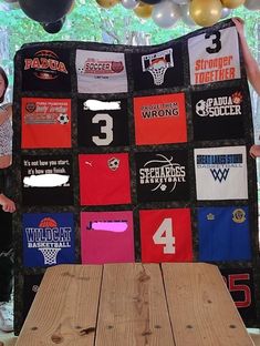 two women holding up a quilt made out of t - shirts with numbers on them