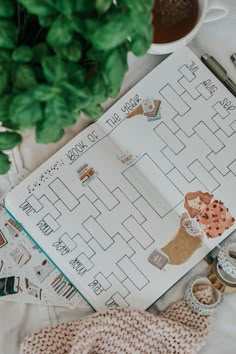 an open planner with stickers on it next to a potted plant and other items