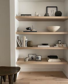 the shelves in this room are filled with books and vases on top of them