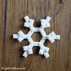 a snowflake made out of legos sitting on top of a wooden table