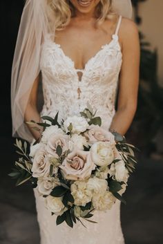 a woman in a wedding dress holding a bouquet