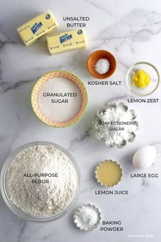 ingredients to make lemon cake sitting on a marble counter top