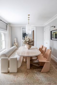 a dining room table with chairs around it and a vase on the table in the middle