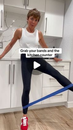 a woman standing on top of a kitchen counter with her leg up in the air