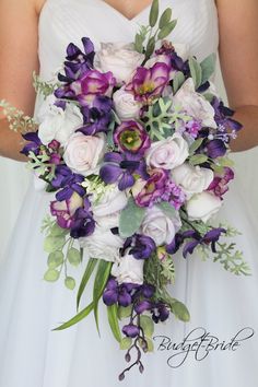 a bride holding a purple and white bouquet