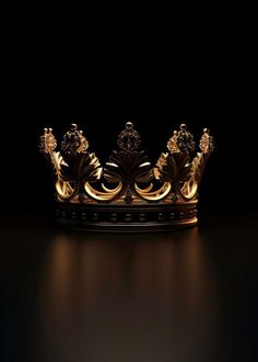 a gold crown on a black surface with light coming from the top and bottom part