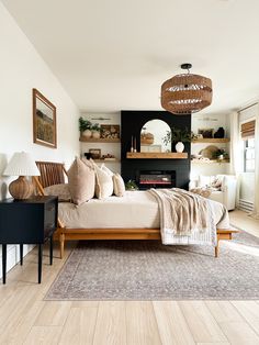 a bed sitting in a bedroom on top of a hard wood floor next to a fireplace