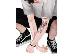 two people with tattoos on their arms and legs, one holding the other's hand