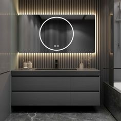 a bathroom with a sink, mirror and bathtub in the corner is lit up by lights on the wall