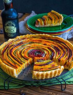 there is a pie that has been cut into pieces and served on a plate with a bottle of beer in the background