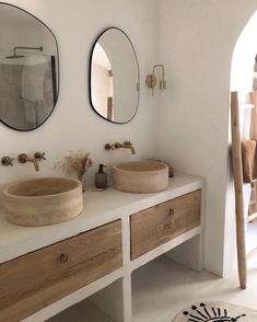 there are two sinks in the bathroom with mirrors on the wall above them and a rug underneath it