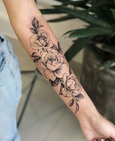 a black and white rose tattoo on the arm