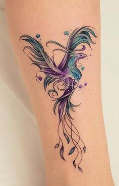 a colorful tattoo on the leg of a woman's leg with watercolors