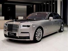 a silver rolls royce parked in a showroom