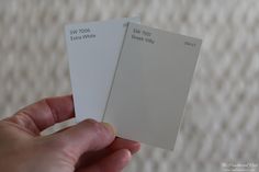 someone holding two white cards in their hand