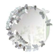 a round mirror with silver leaves and butterflies on the rim, hanging from a wall