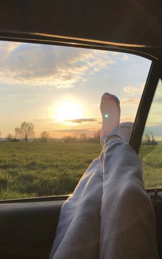 someone is sitting in the back seat of a car with their feet on the dashboard