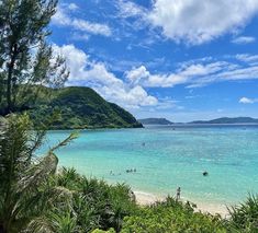 people are swimming in the clear blue water