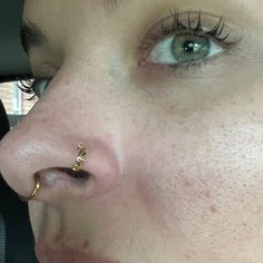 a close up of a person with piercings on their nose