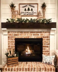 a fireplace decorated for christmas with pine cones and greenery on the mantels