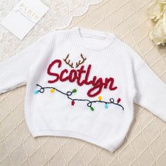 🎁  Adorable Xmas Personalization for Your Little Star   🎅Celebrate the holiday season in style with this adorable and personalized sweater that is perfect for your little one. Each sweater is meticulously hand-embroidered with a festive Christmas design and can be customized with your baby's name for a special touch.Our baby sweaters are not just clothing; they are tiny treasures adorned with intricate hand embroidery that speaks volumes of the care and attention put into each stitch. 🎄 🌟 Pr Embroidered Disney Christmas Sweater, Toddler Christmas Sweater, White Christmas Baby Sweater, Name Sweater Baby, Newborn Embroidered Sweater, Embroidered Baby Name Sweater, Baby Name Sweater, Baby Christmas Gift, Name Sweater