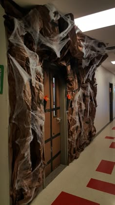 the hallway is decorated with plastic wrap and red carpeted flooring, along with two doors that are covered in brown paper