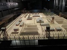 a model of a prison with several jail cell buildings in the background at night time