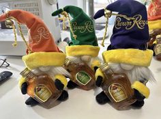 three gnomes wearing hats and holding bottles of honey on a table in an office