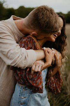 a man and woman embracing each other in a field