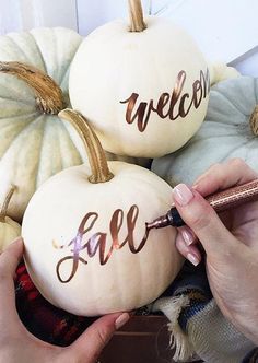 two white pumpkins with the words welcome fall painted on them