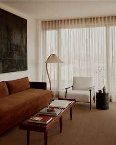 a living room filled with furniture and a large painting hanging on the wall above it