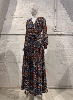 Stunning vintage 1970s maxi dress floral allover pattern if orange, rust, white and turquoise on navy background   v-neck bishop style sleeve with covered button closure at cuffs pleated skirt matching belt dress is fully lined apart from sleeves zip at rear great vintage condition no composition label  lining acetate size 36 please refer to measurements armpit to armpit 44.5 cm shoulder to shoulder 38.5 cm sleeve  waist 34.5 cm hip free 63 cm length 143 cm If you have any other questions please Fall Floral Print Orange Maxi Dress, Orange Floral Print Long Sleeve Maxi Dress, Retro Floral Print Maxi Dress For Fall, Fall Retro V-neck Maxi Dress, Maxi Dress Floral, Allover Pattern, Belt Dress, Navy Background, Bishop Sleeve