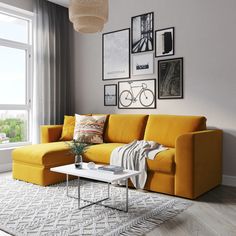 a living room with yellow couches and pictures on the wall above it's coffee table