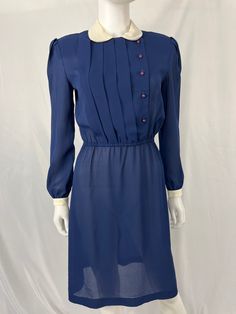 36" Bust 30" Waist 34" Hips 40" Shoulder to hem This item is used. Please wash before wearing, we do not launder. Staining/discoloring on collar and white sleeves. PLEASE see photos No other flaws found, great vintage condition. Shoulder pads attached, can be removed. Classic Blue Dress For Vintage Fashion, Blue Vintage Dress With Buttons For Vintage Fashion, Blue Vintage Dress With Buttons, Retro Blue Button-up Dress, Blue Peter Pan Collar Dress For Daywear, Blue Knee-length Vintage Dress For Vintage Fashion, Vintage Blue Button-up Dress, Classic Blue Collared Dress, Blue Vintage Dress With Buttons For Spring