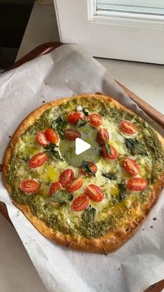 a pizza sitting on top of a piece of wax paper next to a window sill