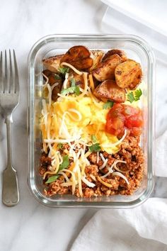 a glass container filled with food next to a fork