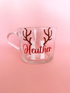 a clear cup with two reindeer antlers on it and the words heather written in red