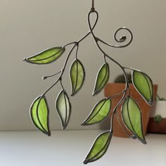 a wind chime with green leaves hanging from it