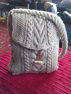 a knitted purse sitting on top of a red blanket