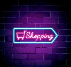 a neon sign with the word shopping on it in front of a purple brick wall