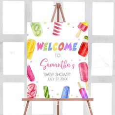 an easel with a welcome sign on it and popsicles in watercolors