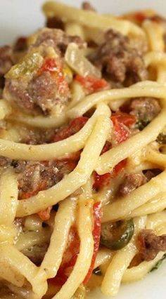 a white plate topped with pasta and meat