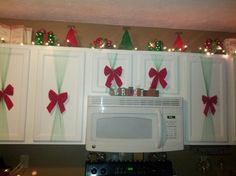 a white microwave oven sitting on top of a counter next to christmas decorations and lights